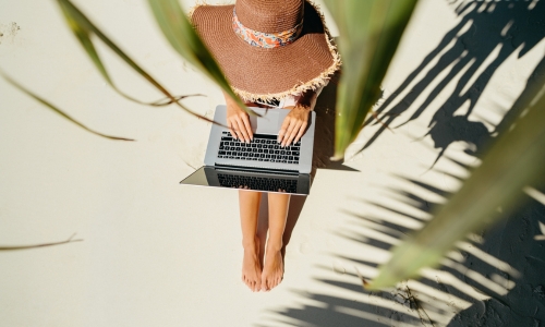 Woman Using Laptop at the Beach